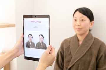 施術前の写真と比べながら施術後の写真を撮る様子