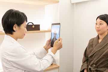 施術前に顔を撮影する様子