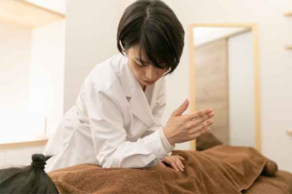 肘を使って押圧する様子