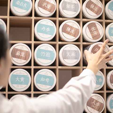 生薬ボトルを選んで取り出す様子